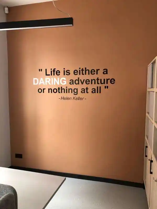 Uzraksts uz sienas Life is either a daring adventure or nothing at all