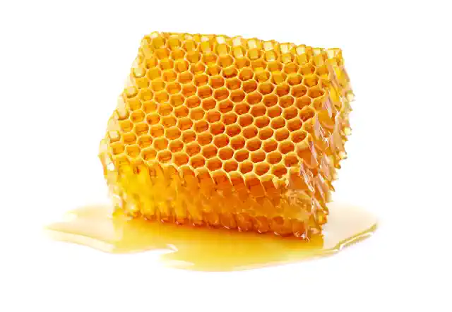 Medus kāres gabals ar notecējušu medu kā medus etiķešu fons