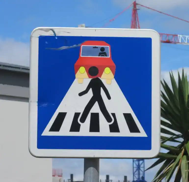 Zīme Gājēju pāreja auto lukturu gaismā