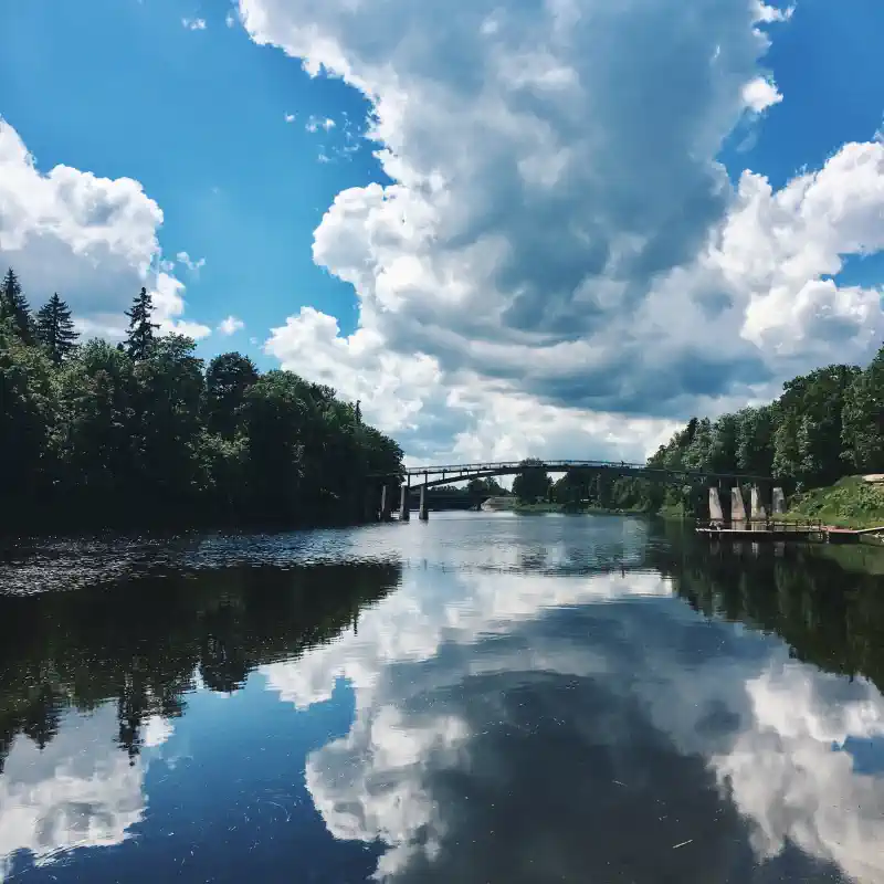 Kanvas bildes - liela, lēna Latvijas upe, tilts, zaļi krasti, zilas debesis, balti mākoņi