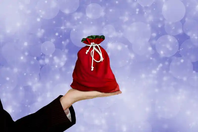 Ziemassvētku dāvanas - sarkans maisiņš plaukstā